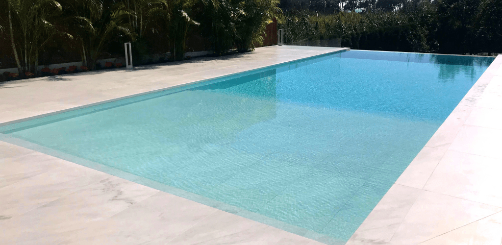 Swimming pool tanning ledge in Carrara marble. GodoPools