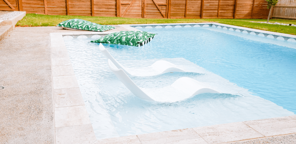 Piscina con pequeña plataforma y mobiliario de Lux Loungers
